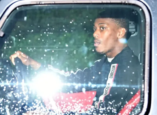  Jadon Sancho hides from the cameras with his hood up in the car as he returns to Manchester United training  - Bóng Đá