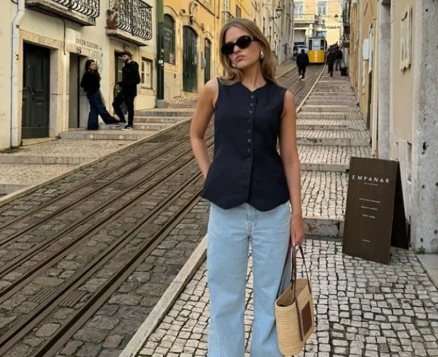 Polina Llieva diện baggy jeans và áo ghi lê màu đen. 