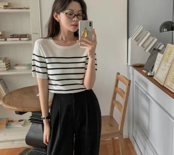 Sự kết hợp giữa áo kẻ ngang và quần âu màu đen đã tạo nên bộ trang phục đúng chất công sở.