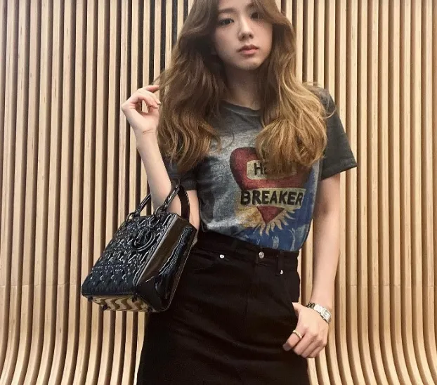 Áo phông họa tiết mix với chân váy ngắn màu đen để tạo nên tổng thể trang phục hài hòa, đẹp mắt.