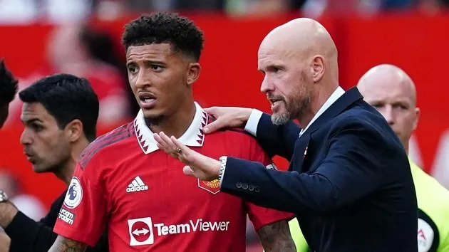 Jadon Sancho hides from the cameras with his hood up in the car as he returns to Manchester United training - Bóng Đá