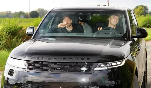 Jadon Sancho hides from the cameras with his hood up in the car as he returns to Manchester United training - Bóng Đá