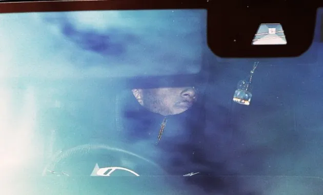 Jadon Sancho hides from the cameras with his hood up in the car as he returns to Manchester United training - Bóng Đá