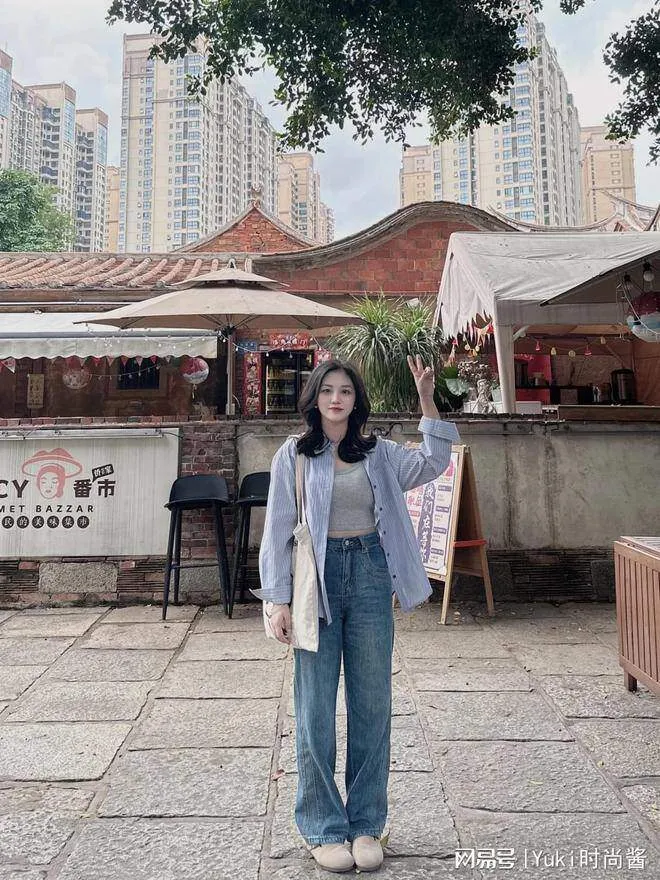 Một chiếc áo sơ mi sọc dọc màu xanh nhạt, kết hợp với quần dài ống đứng màu đen và một đôi giày thể thao màu trắng là hoàn hảo.