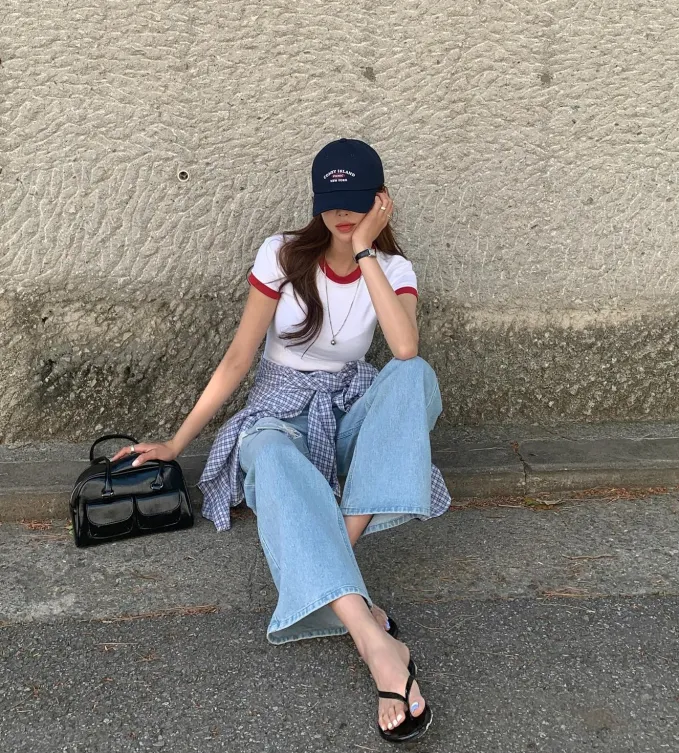 Tổng thể trang phục thêm nổi bật nhờ mẫu áo sơ mi kẻ ô buộc ngang hông.