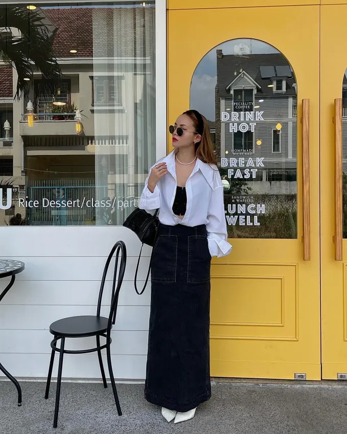 Yến Trang diện chân váy denim màu đen theo cách đầy phóng khoáng, quyến rũ.