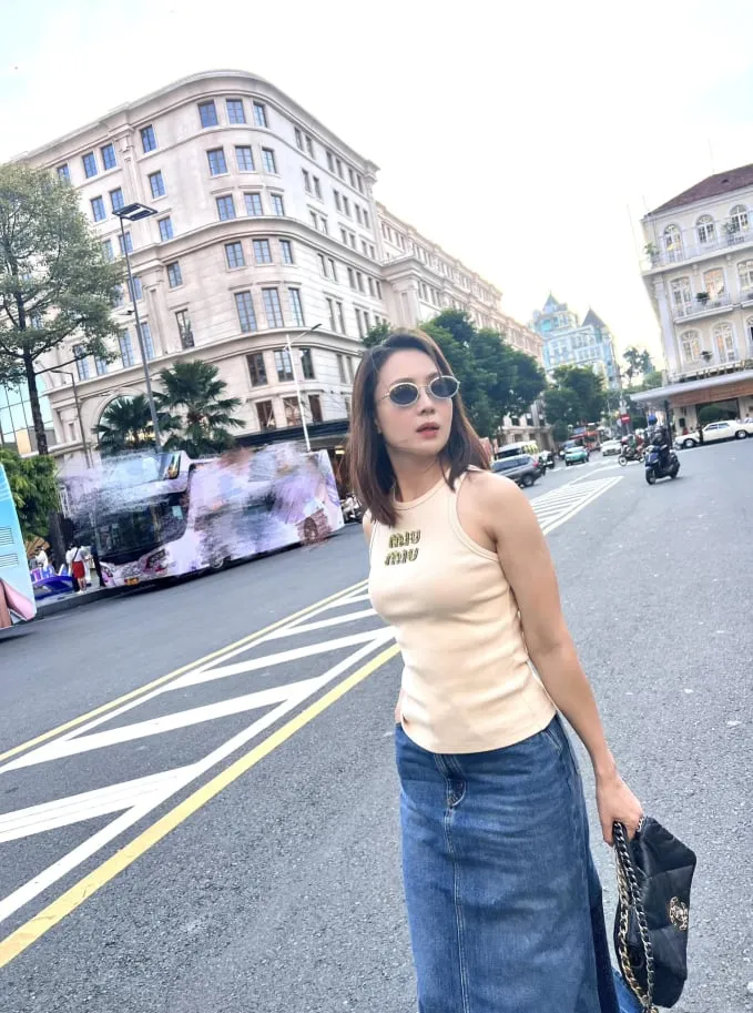 Sự kết hợp giữa áo tank top màu trắng và chân váy denim, bỏ qua thao tác sơ vin, chiều cao cũng không bị