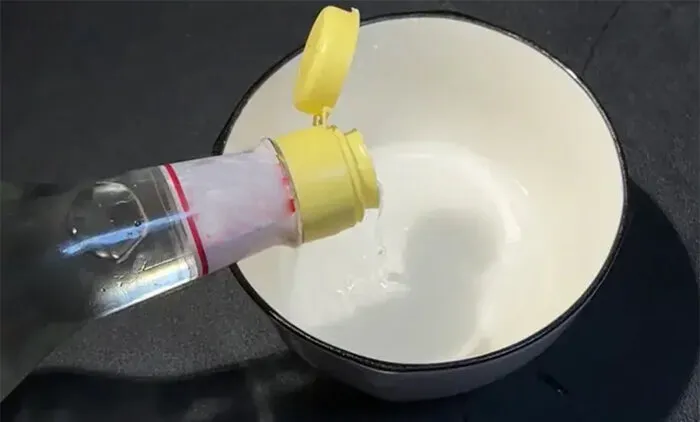 Trong một chiếc bát nhỏ, trộn 20ml giấm trắng với 10gr muối và thêm 150ml nước ấm vào.