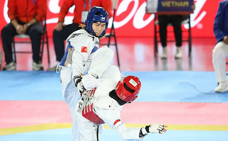 Ánh Tuyết (xanh) áp đảo đối thủ Indonesia ở chung kết hạng 53 kg nữ môn taekwondo. Ảnh: Lâm Đồng.