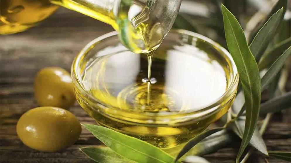 olive oil being poured into a bowl